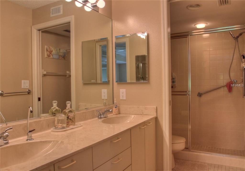 Bathroom with double sinks and shower stall.