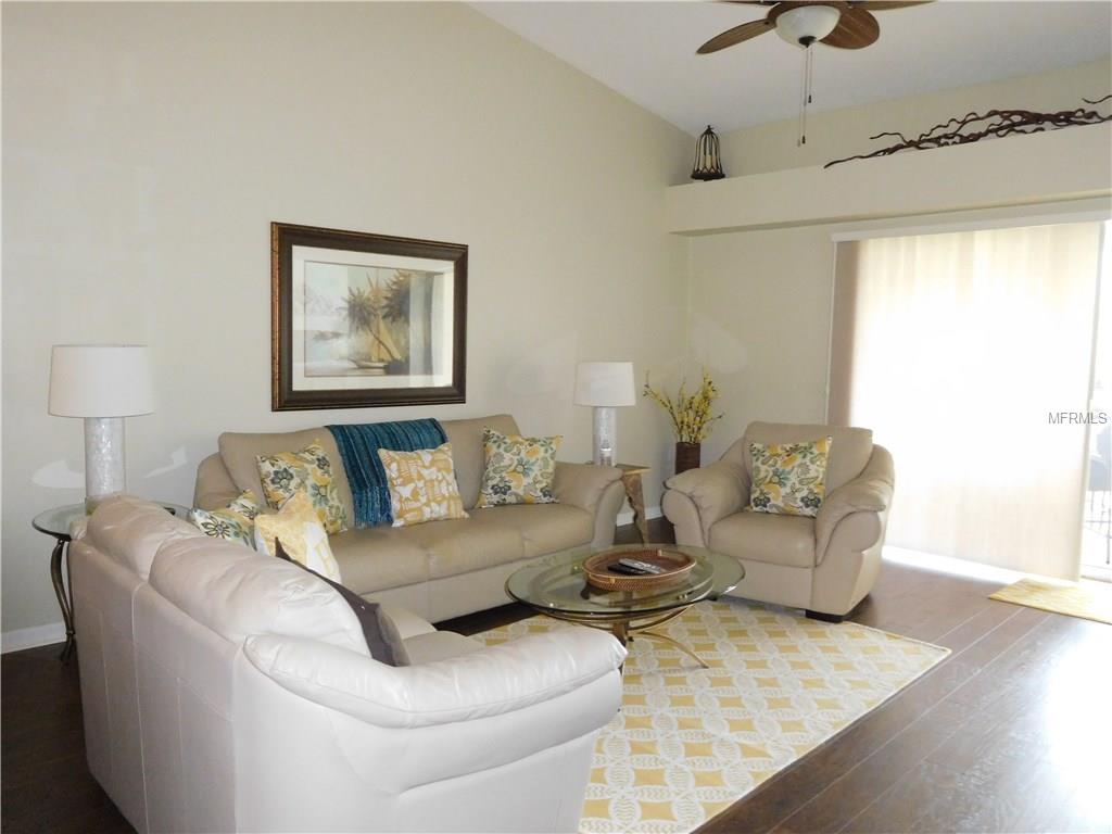 Living room with white couches and a rug.