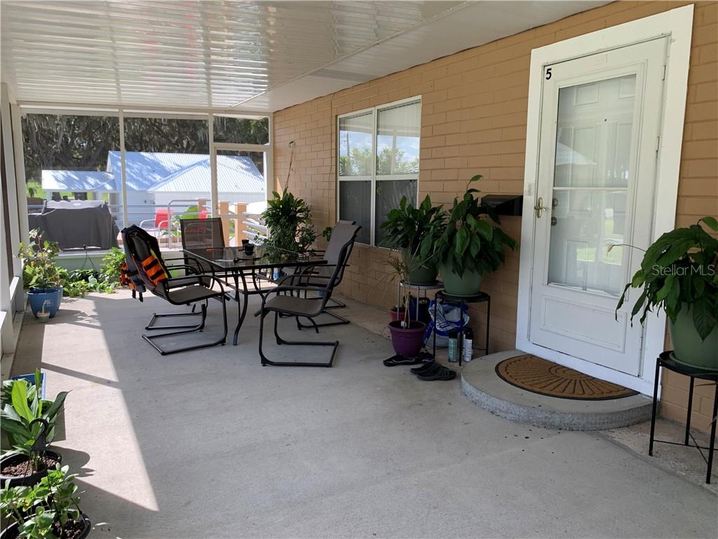 Front porch with patio furniture and plants.