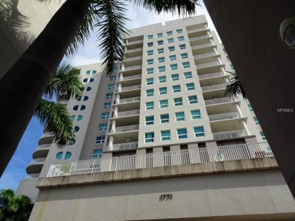 Tall modern condo building with balconies.