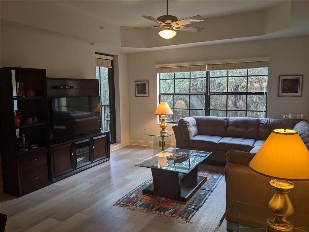 Living room with sofa, TV, and windows.