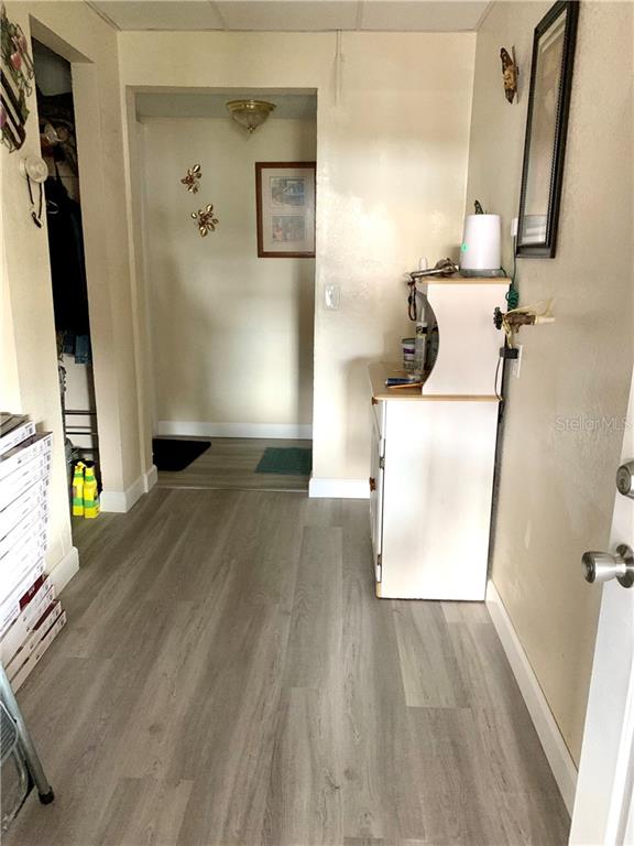 A light wood floor hallway with a white cabinet.