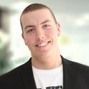 Headshot of a smiling man in a suit.