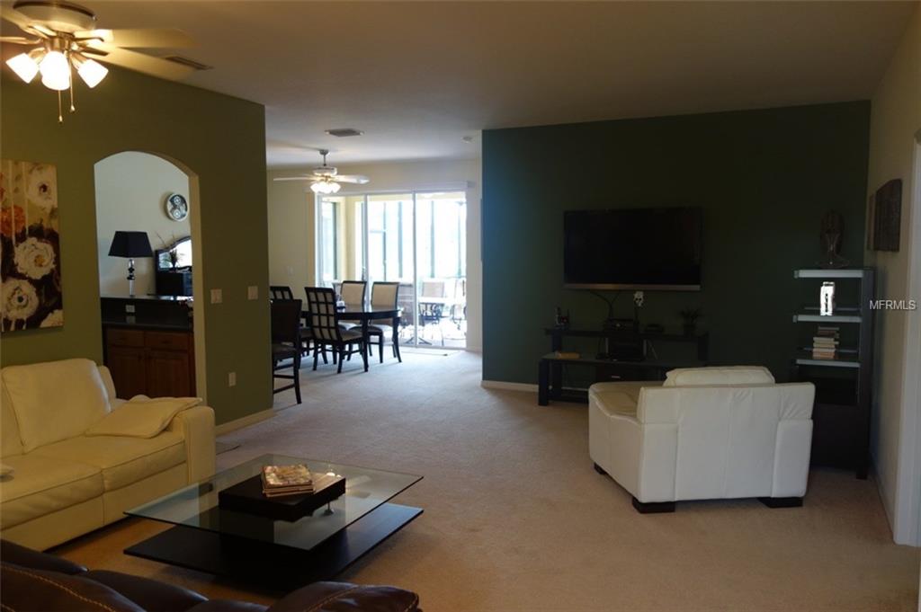 Living room with white furniture and TV.