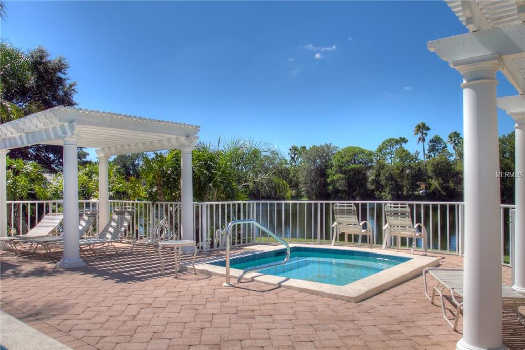 Small pool with pergola and chairs.