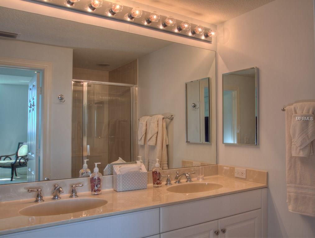 Double vanity bathroom with shower and towels.