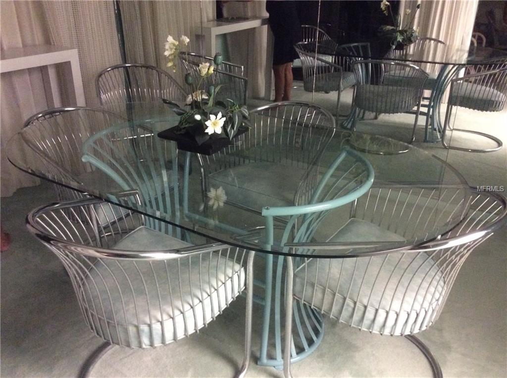 Glass dining table with metal chairs.