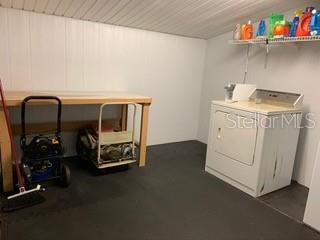 Laundry room with washer, dryer, and shelves.