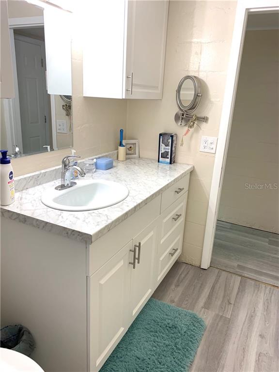 Bathroom vanity with white cabinets and sink.