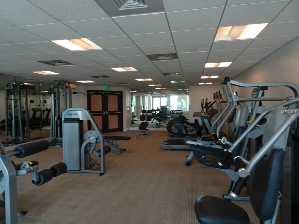 Well-lit gym with various exercise equipment.