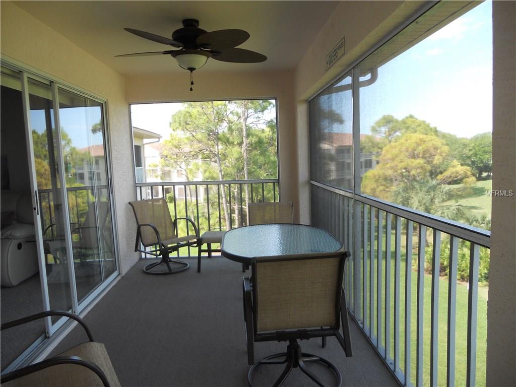 Screened patio with furniture and a view.