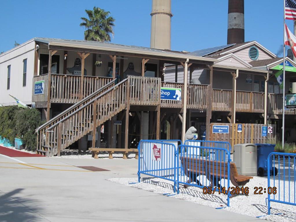 Wooden shop building with stairs and a blue fence.