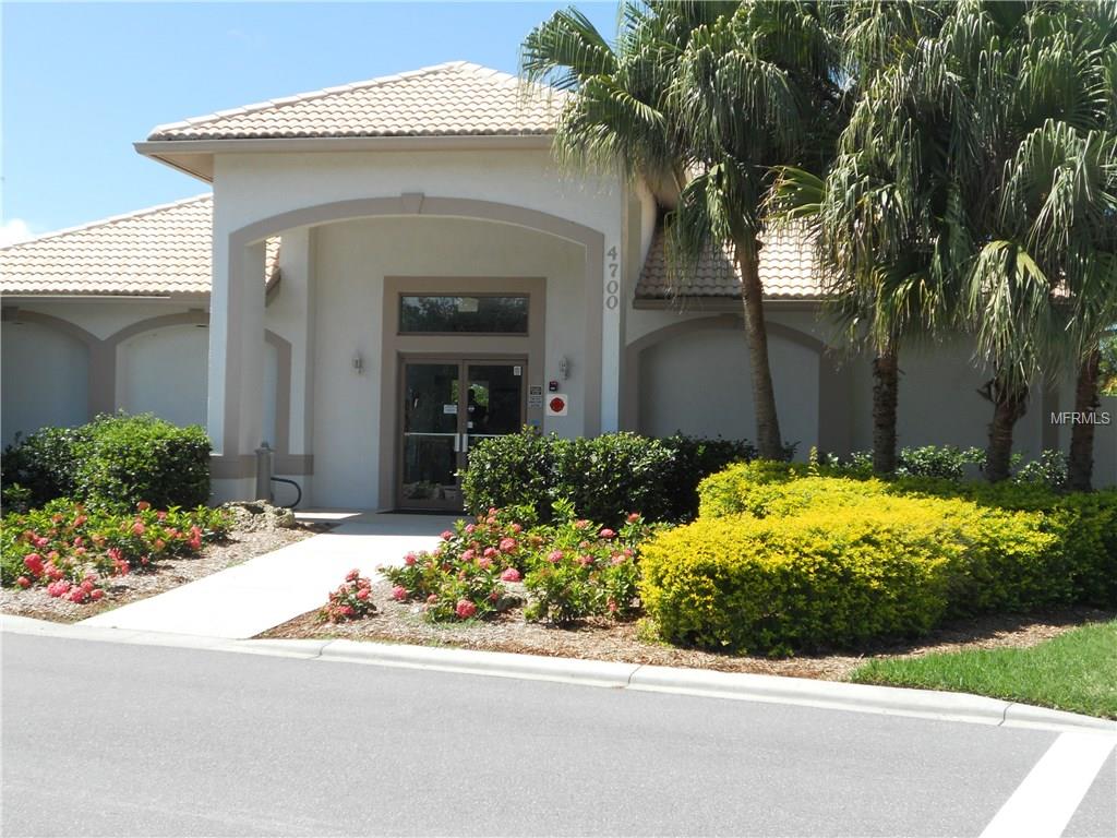 Building entrance with palm trees and flowers.