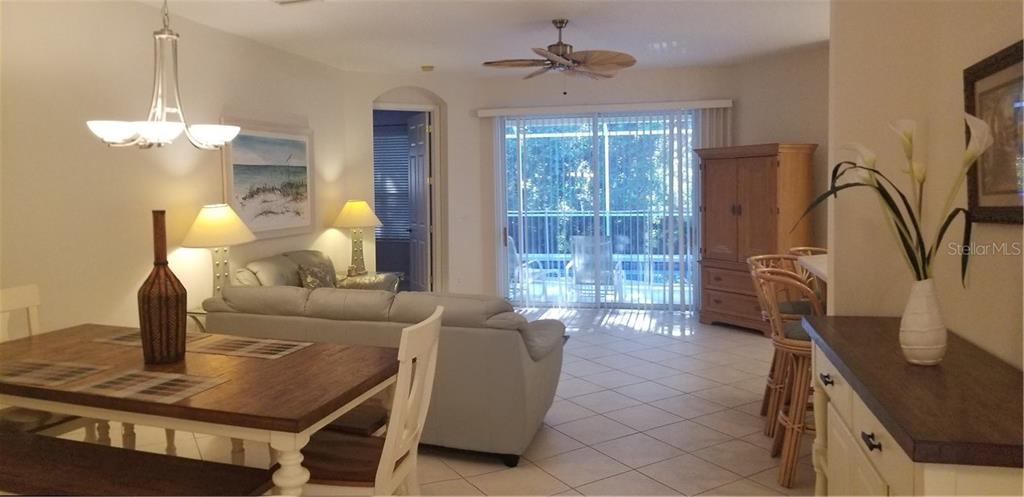 Living room with couch, dining table, and patio door.