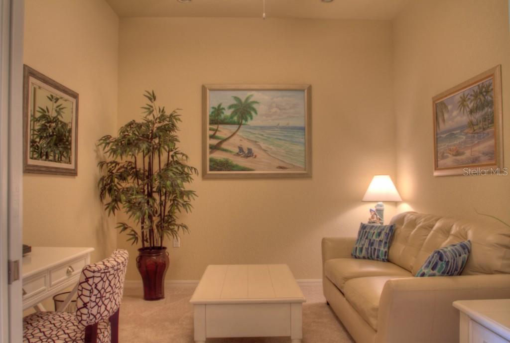 Living room with couch, table, and paintings.