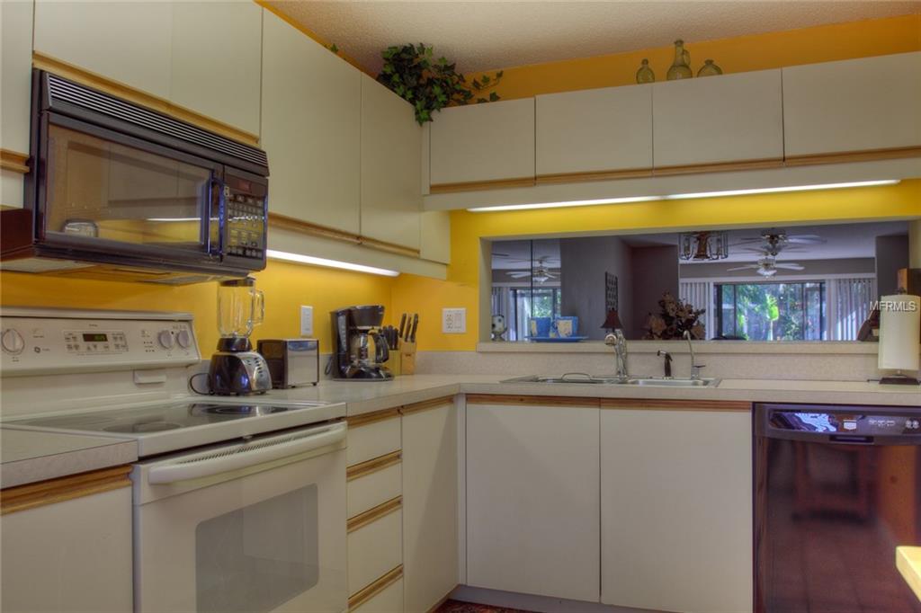 White kitchen with appliances and yellow walls.