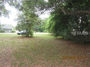 A grassy lot with trees in the background.