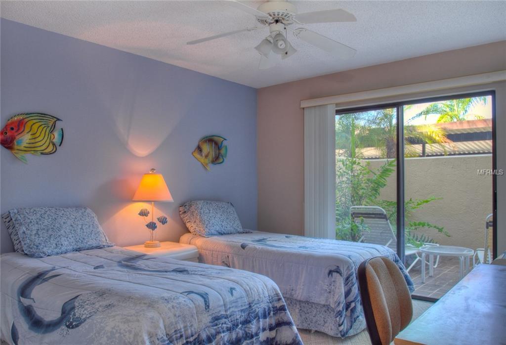 Two twin beds in a bedroom with patio doors.