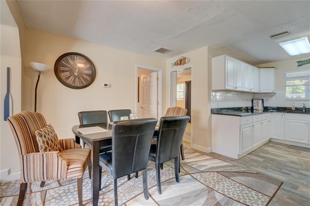 Dining room with white cabinets and a rug.