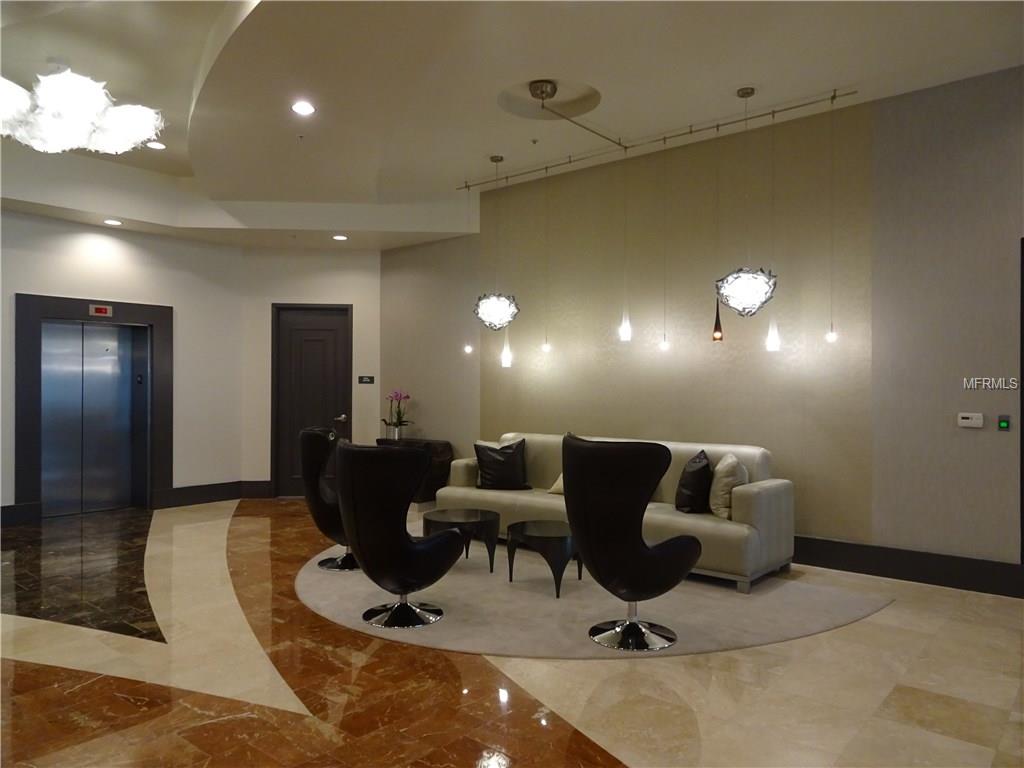 Modern lobby with seating and an elevator.