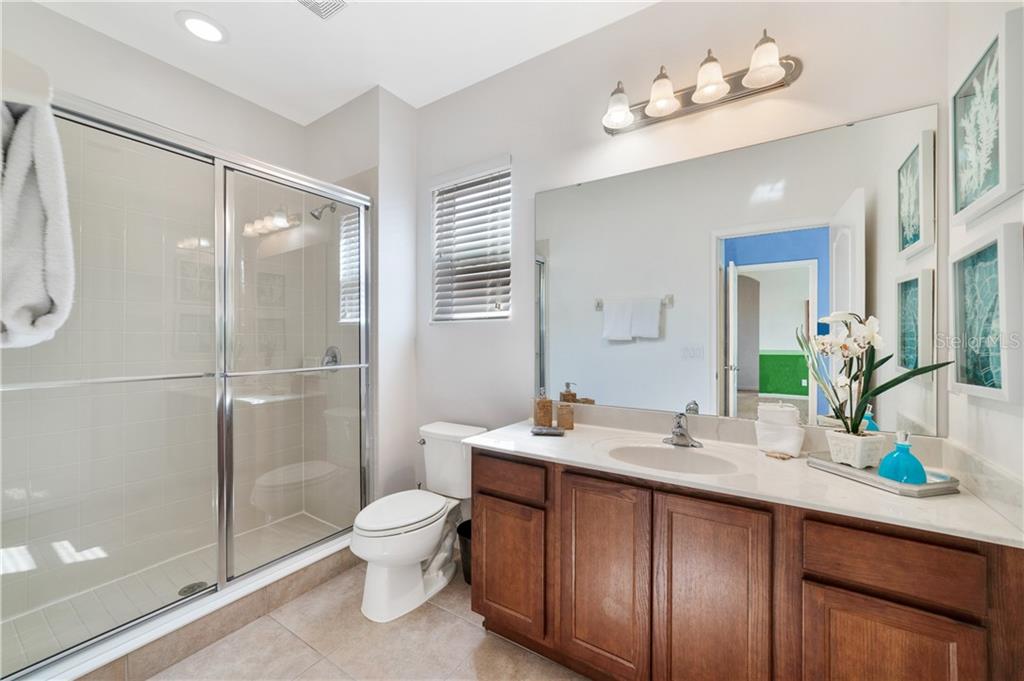 Bathroom with shower, sink, and cabinets.