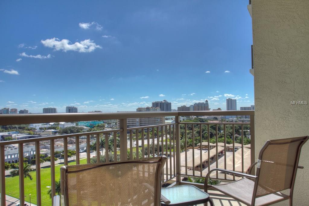 Balcony view of city skyline with chairs.