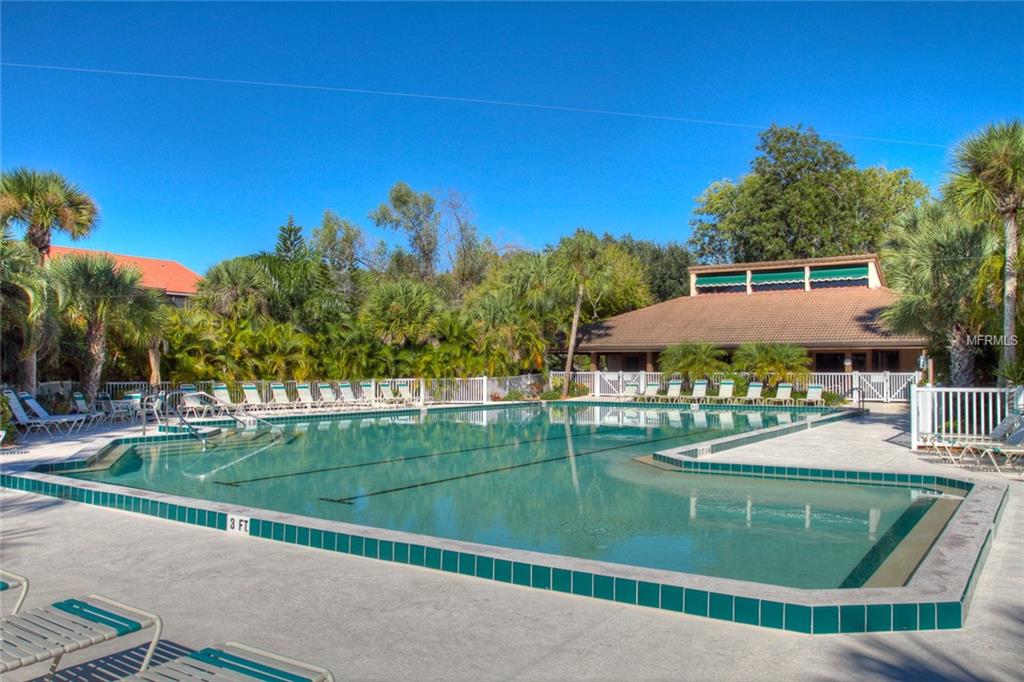 Swimming pool with lounge chairs and building.