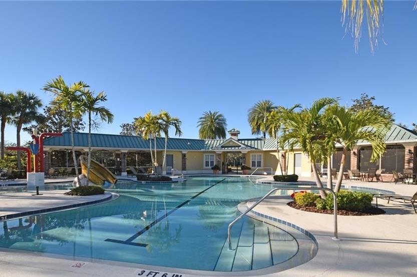 Community pool with palm trees and a slide.