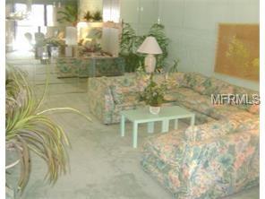 Living room with couch, coffee table, and plants.