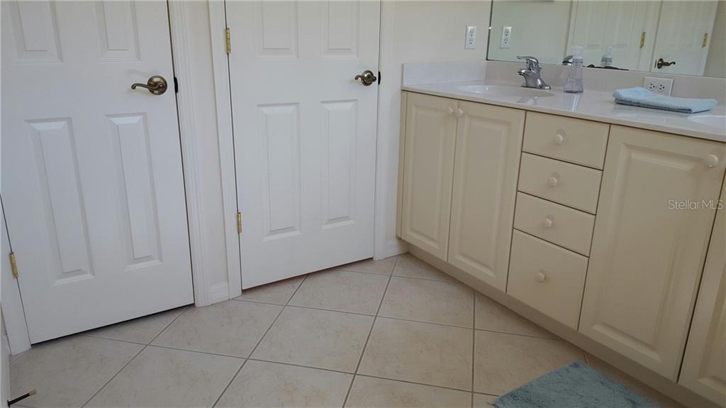 White bathroom vanity with drawers and doors.