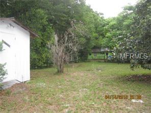 A small shed in a grassy backyard.