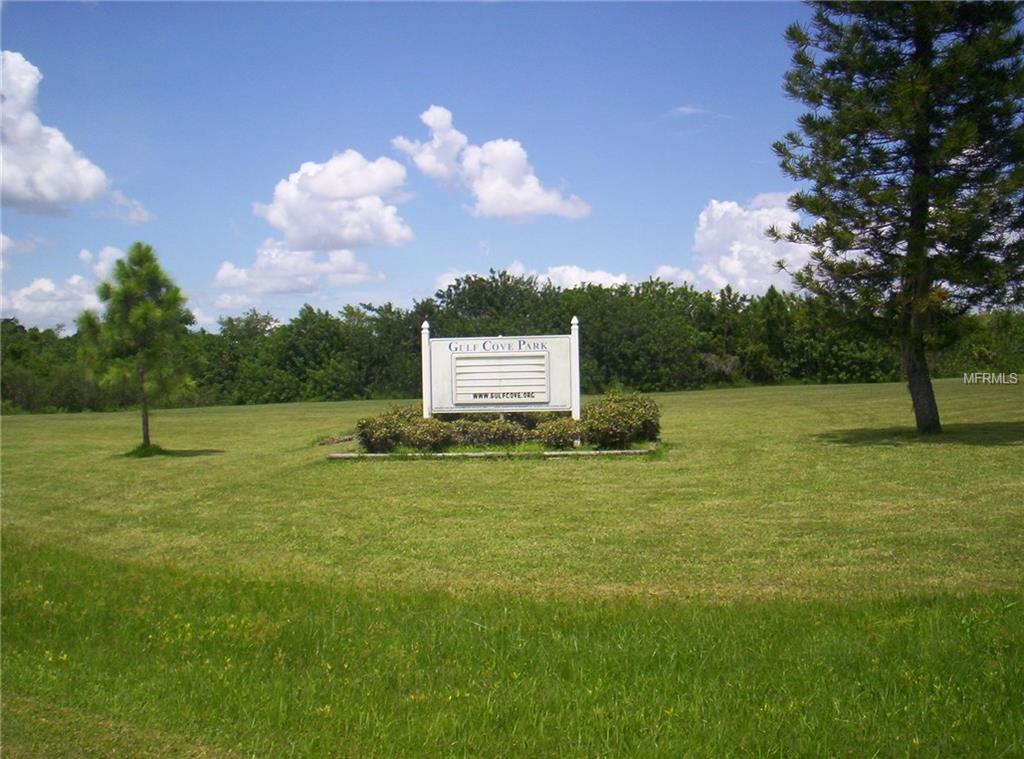 Gulf Cove Park sign with trees and grass.