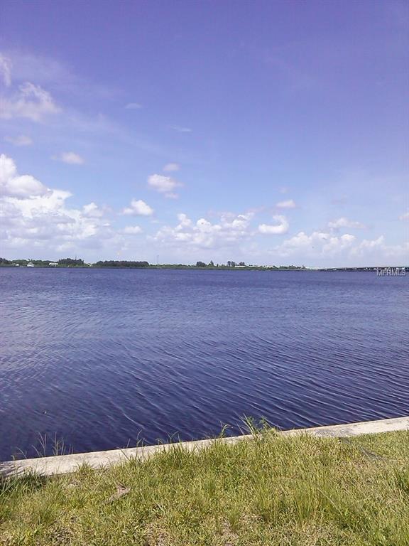 Blue water and green grass with a blue sky.