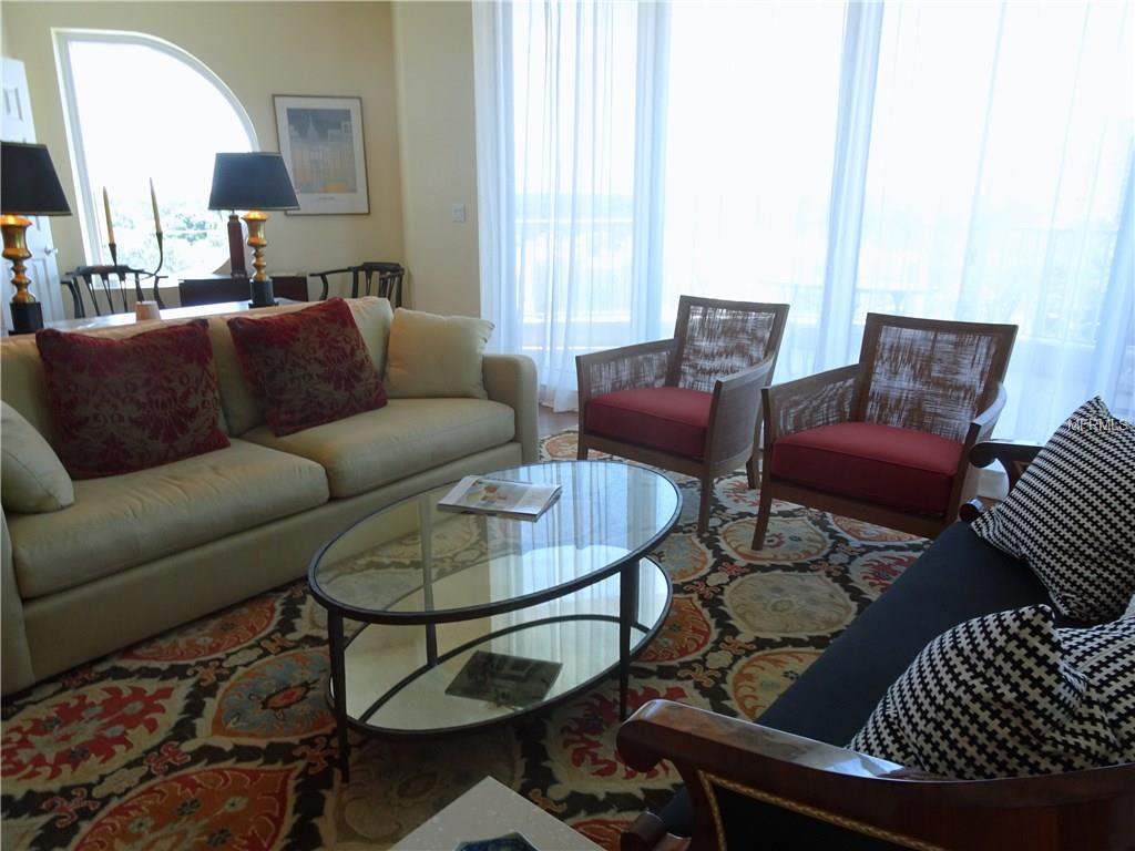 Living room with couch, chairs, and rug.