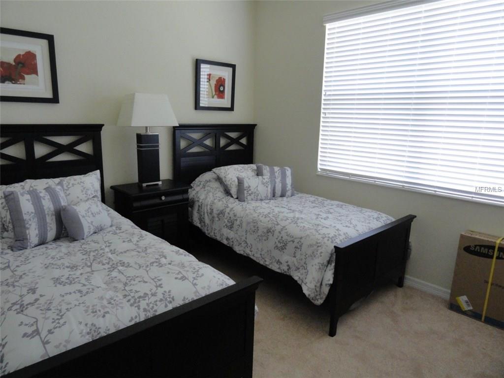 Two twin beds with floral bedding in a room.