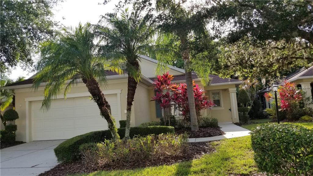 Front view of a single-story house with palm trees.