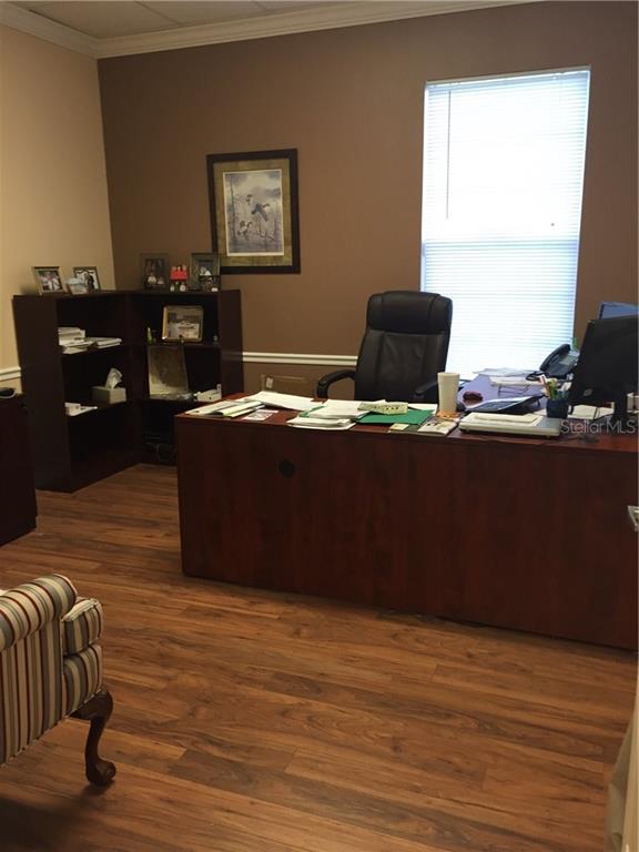 Office with a desk, chair, and wood floor.