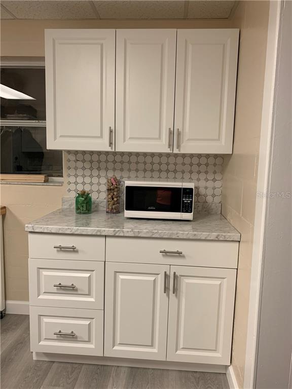 White kitchen cabinets with a microwave.