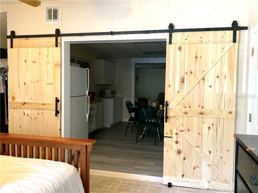 Wooden sliding barn doors open to kitchen.