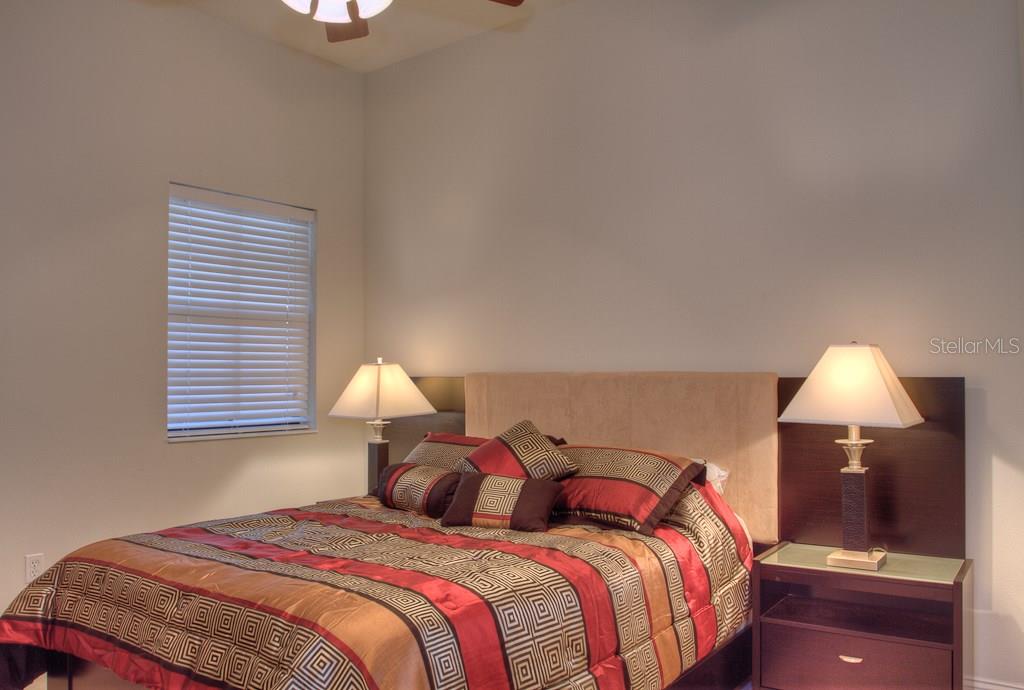 Bedroom with patterned bedding and nightstand.