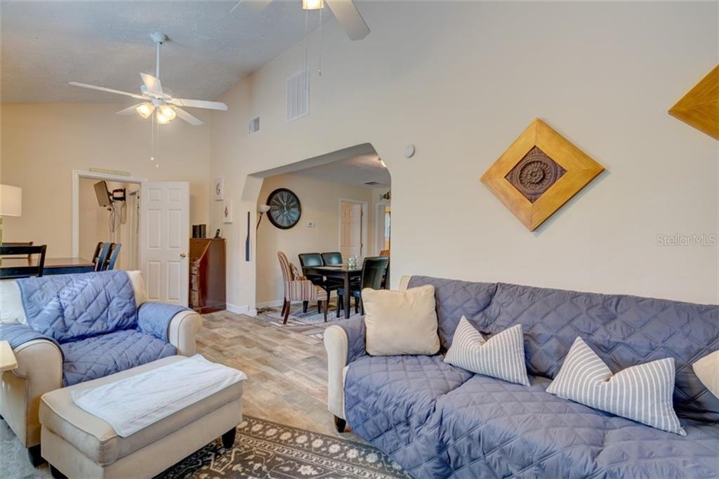 Living room with couch, chairs, and a dining area.