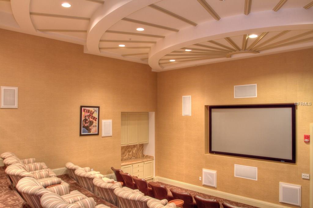 Home theater with projector screen and seating.