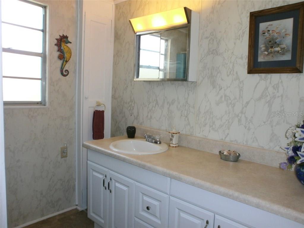 White bathroom vanity with a sink and mirror.