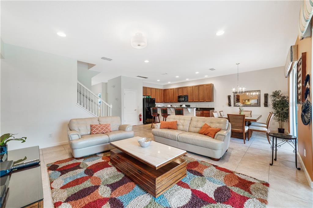 Living room with couches, rug, and kitchen.