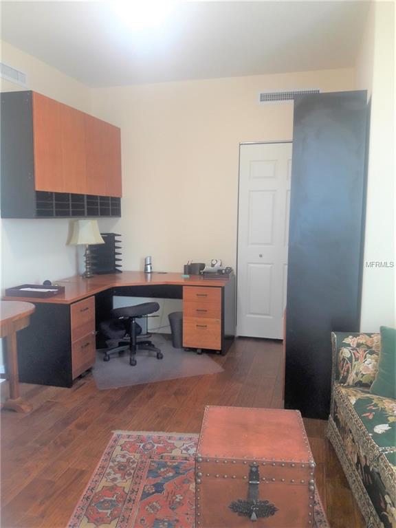 Home office with desk, chair, and rug.