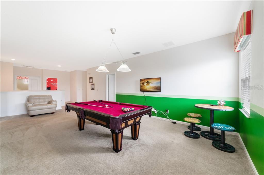 Pool table in a game room with green walls.