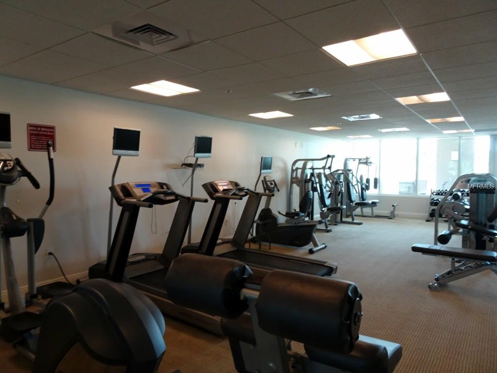 Modern gym with treadmills and weight machines.