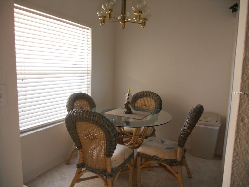 Dining room with wicker chairs and blinds.