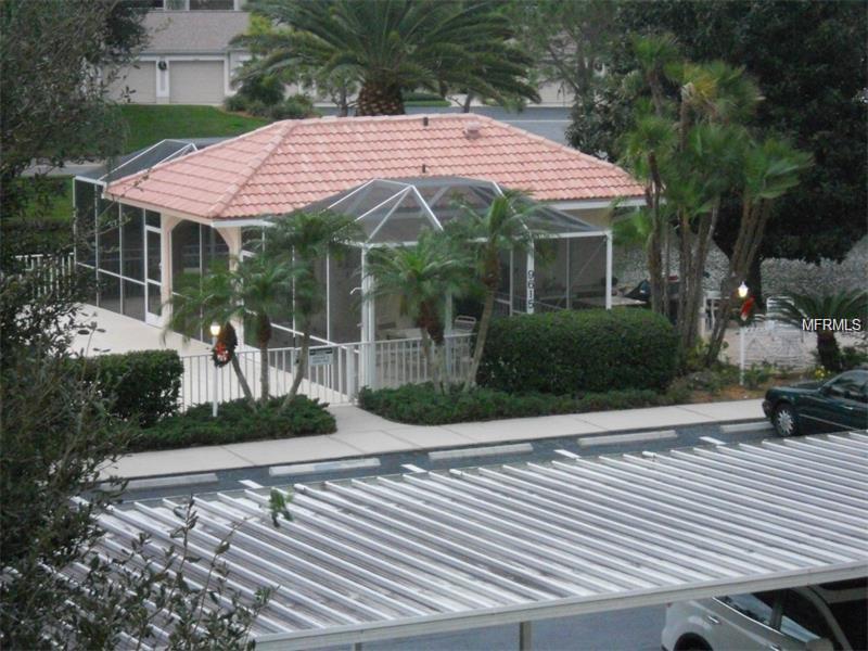 Enclosed patio with tiled roof and palm trees.