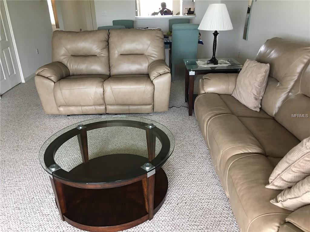 Tan leather sofas and a glass coffee table.